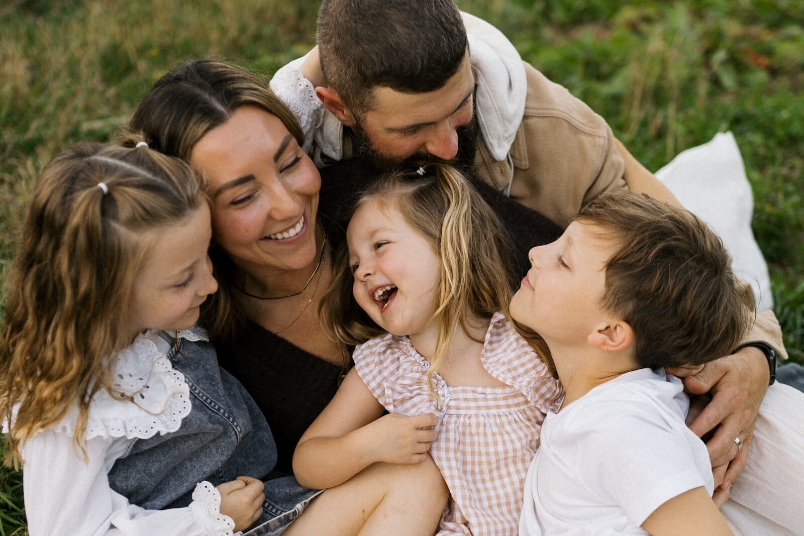 Parents laughing with their three children in their arms